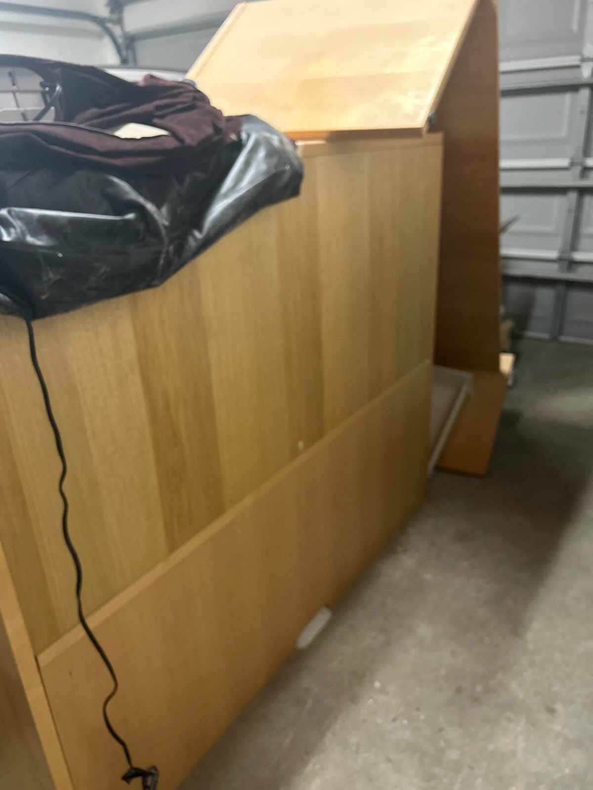 Wooden desk and dresser in a garage ready to be hauled away